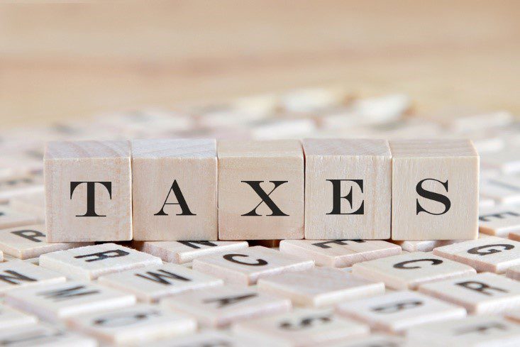 Concept image with the word TAXES spelled out in wooden blocks
