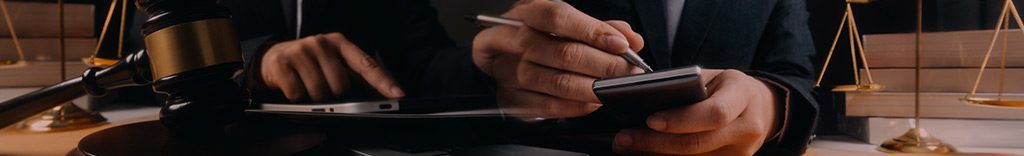 Business and lawyers discussing contract papers with brass scale on desk in office.