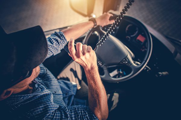 A truck driver is talking on a dispatch radio.
