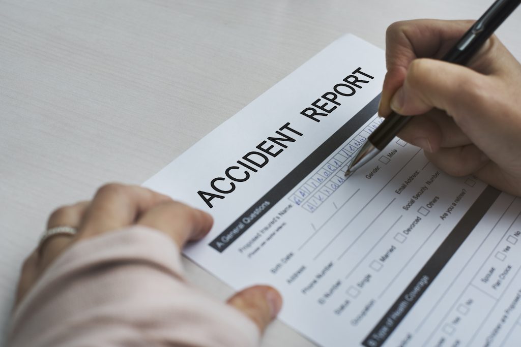 A person fills out an accident report form