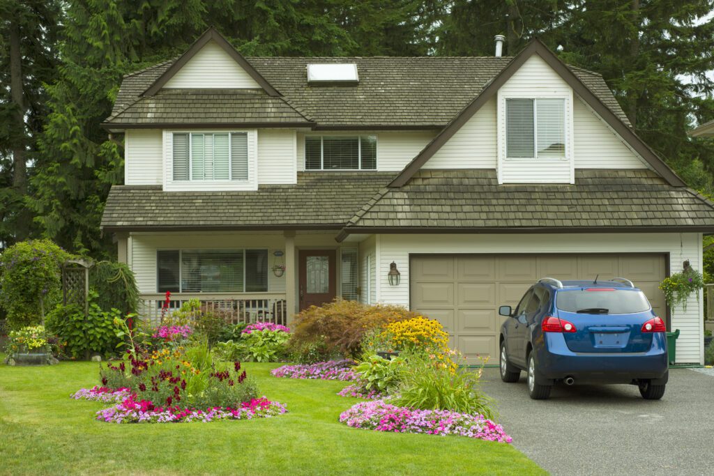 A home with a blue car in the driveway.